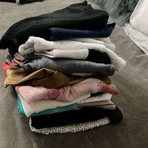 A stack of clothes. Mostly size medium.